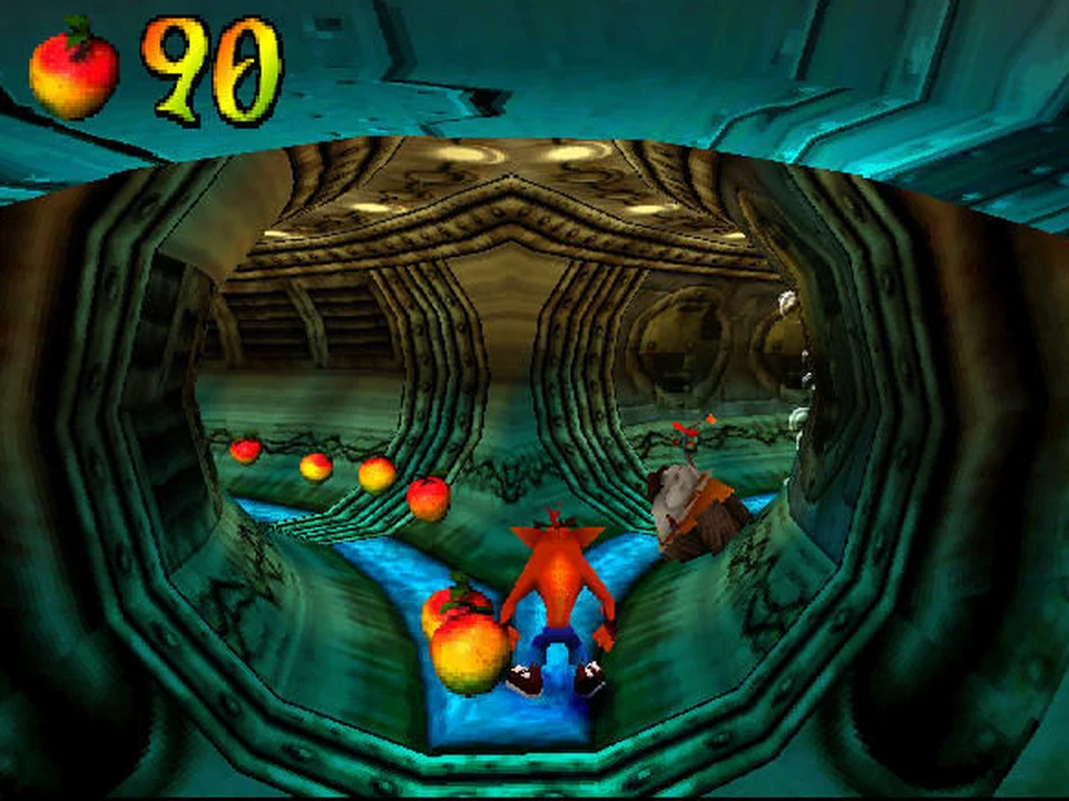 Crash slides through a sewer tunnel filled with Wumpa fruits in Crash Bandicoot 2